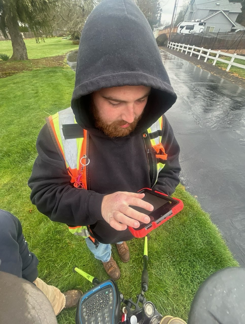 KLS surveyor reviewing field data on a tablet in the rain
