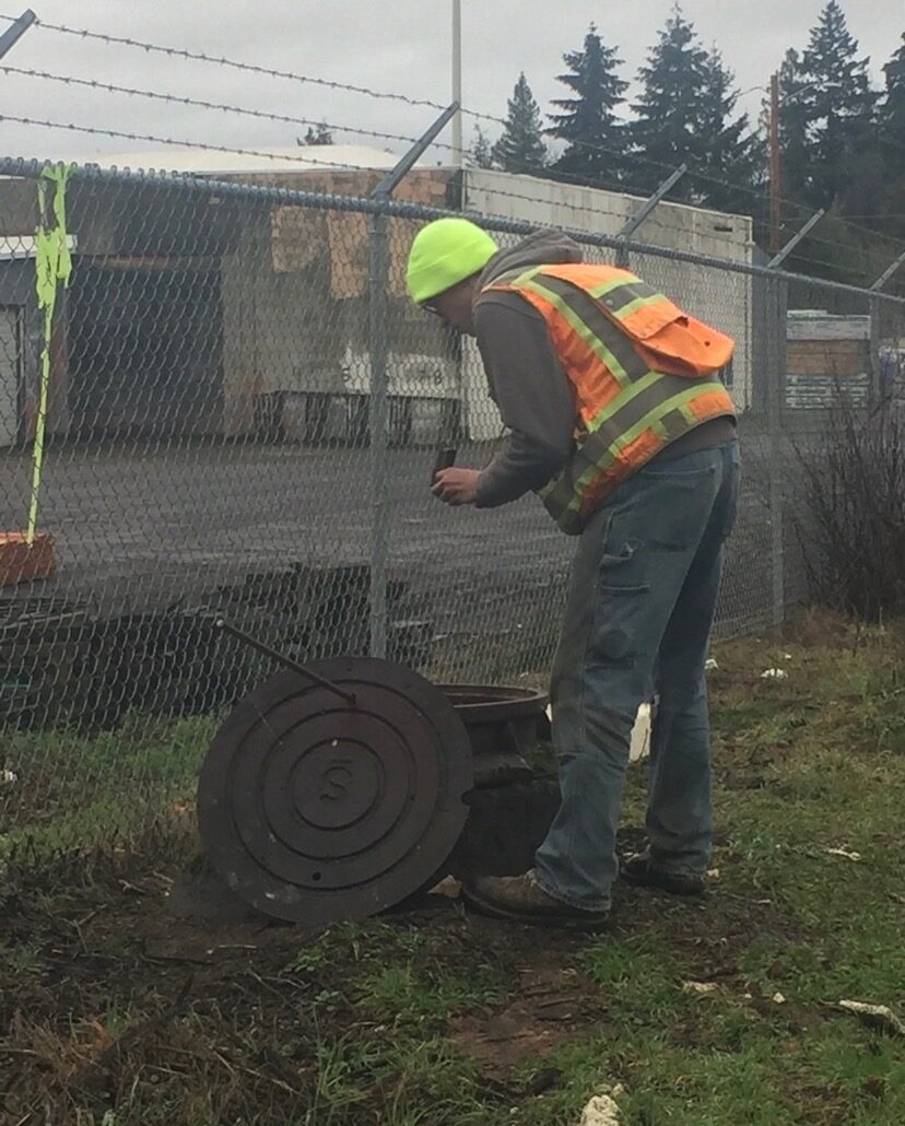 KLS field crew member documenting site evidence near an industrial property